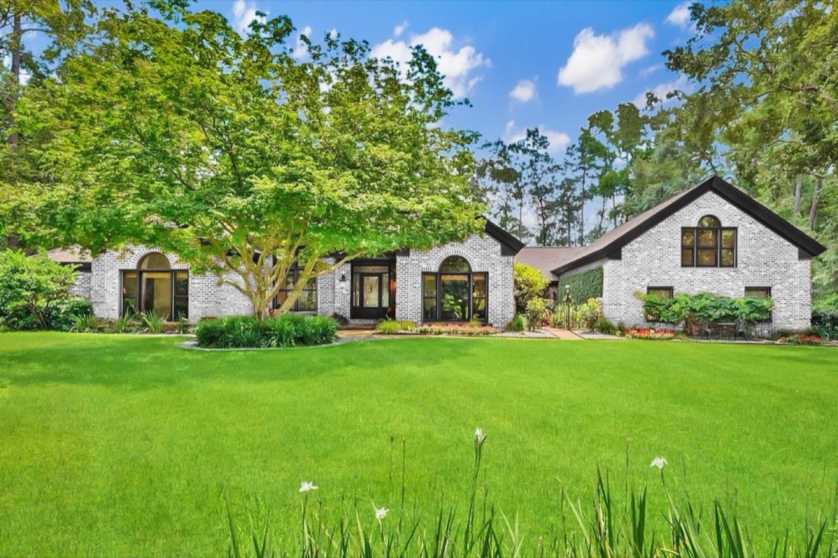 Brick ranch home with arched windows and a wide front lawn