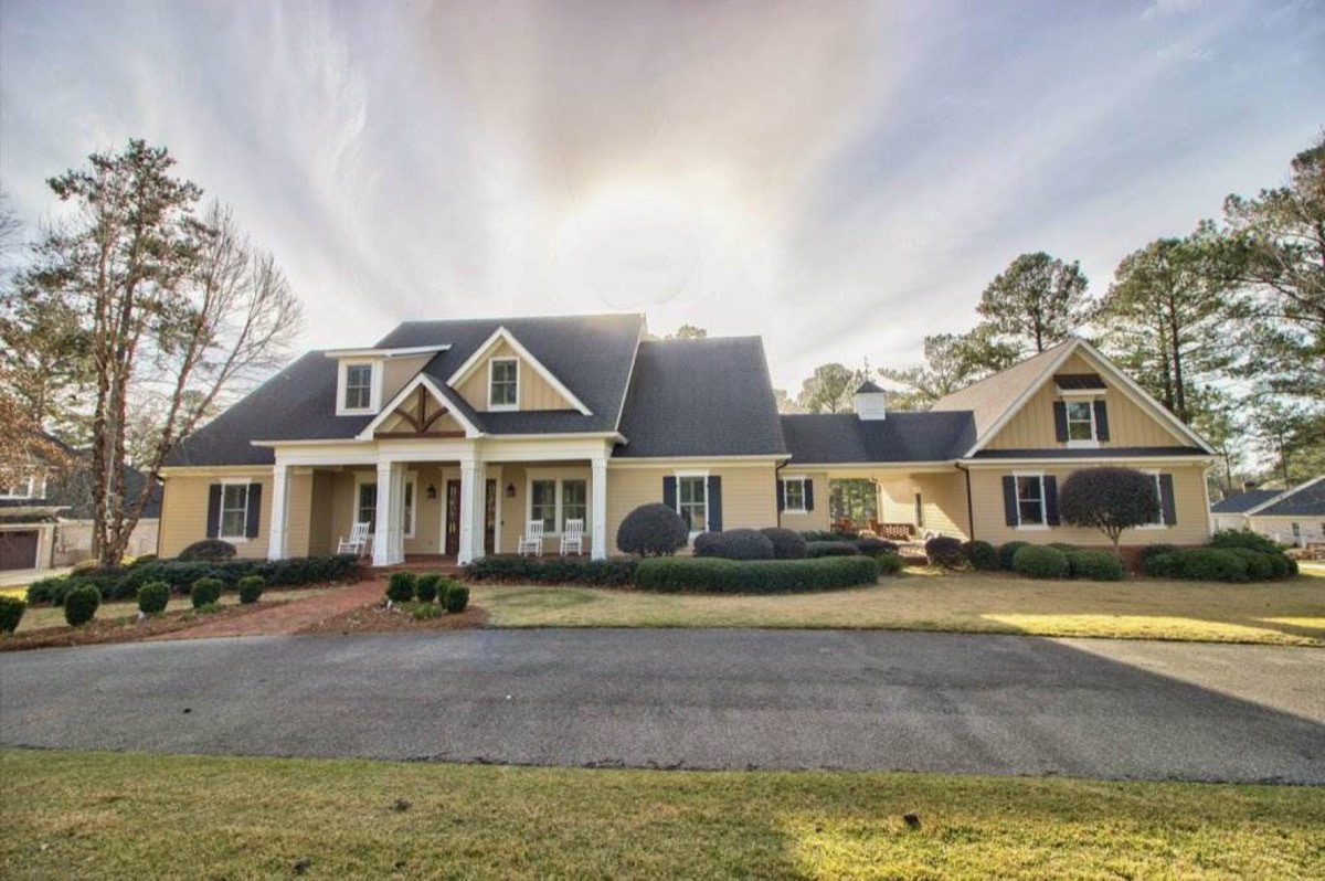 Two-story home with a columned front porch, dormers and a circular drive